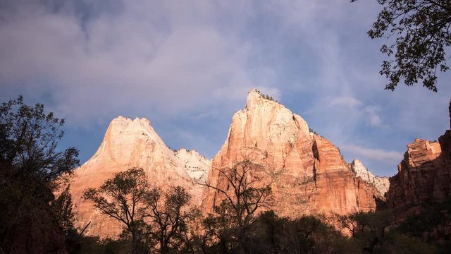 Time lapse of red cliff walls lit up as clouds move by