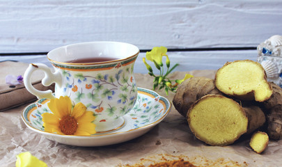 A cup of tea on a table with ginger and ground turmeric. Concept of health.