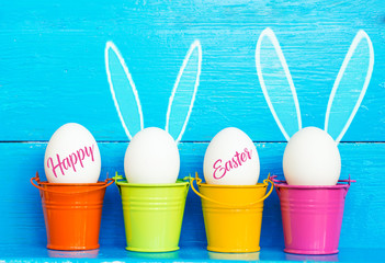 Easter eggs with Rabbit ears in colored buckets, selective focus image, Card Happy Easter 