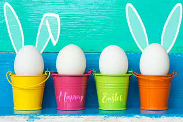 Easter eggs with Rabbit ears in colored buckets, selective focus image, Card Happy Easter 
