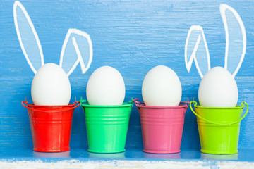 Easter eggs with Rabbit ears in colored buckets, selective focus image, Card Happy Easter 