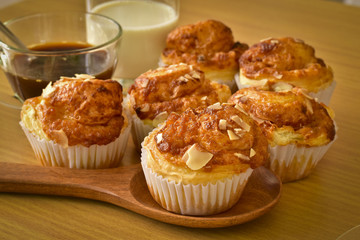 Delicious homemade almond muffins and a glass of milk and coffee on wooden table. Healthy food concept.