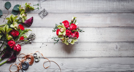 Bouquet of red roses, hearts, callas, carnations and ribbons on the table