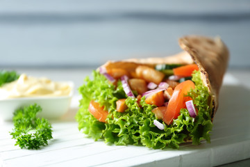 Tasty kebab sandwich on wooden board