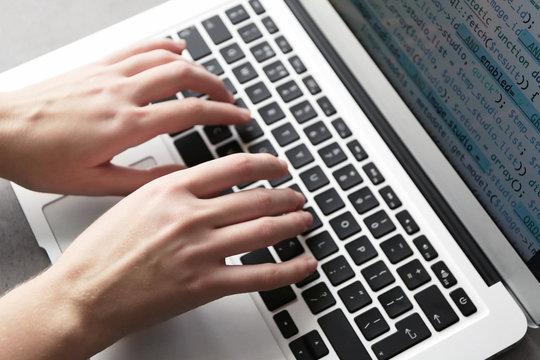 Programmer using laptop, closeup