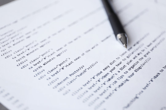 Script code on paper and pen, closeup. Software development concept