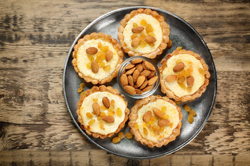 Metal tray with delicious crispy tarts on wooden table