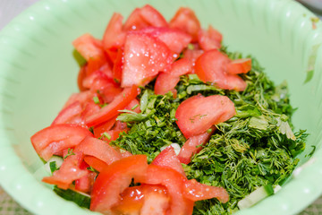 Salad in a bowl. Cut tomato, cucumber, greens. Healthy food, home cuisine.