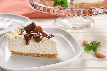 Piece of delicious cheesecake with chocolate on white plate