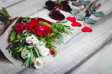 Bouquet of white and red tulips lies on a wooden table