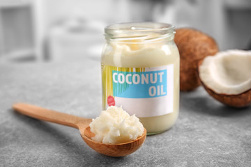 Spoon and jar with coconut oil on table © Africa Studio