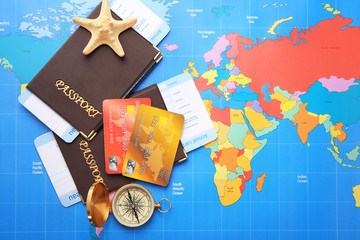 Credit cards with passports and tickets for vacations on world map background