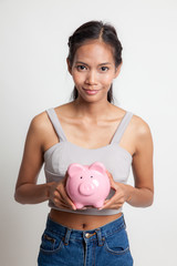Fototapeta na wymiar Young Asian woman with a pig coin bank.