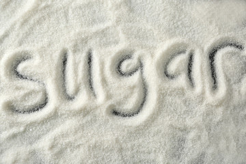 Written word SUGAR on dark background