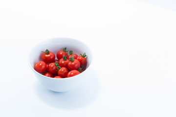 Cherry tomatoes harvested from home cultivation in a white bowl isolated on white background