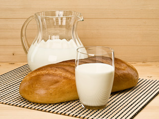 Glassware filled with milk and a white loaf long loaf