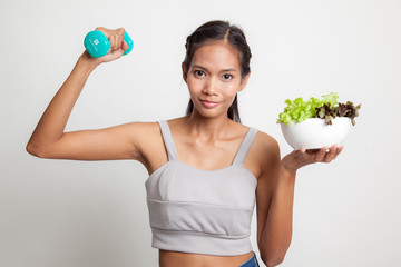 Healthy Asian woman with dumbbells and salad.