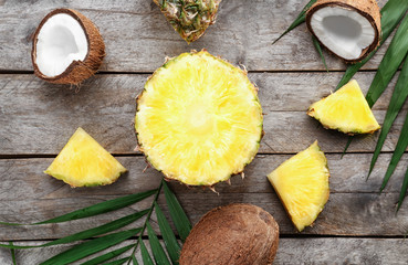 Fototapeta na wymiar Composition of fresh pineapple and coconuts on wooden background