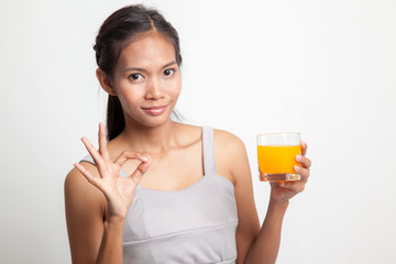 Young Asian woman show OK drink orange juice.