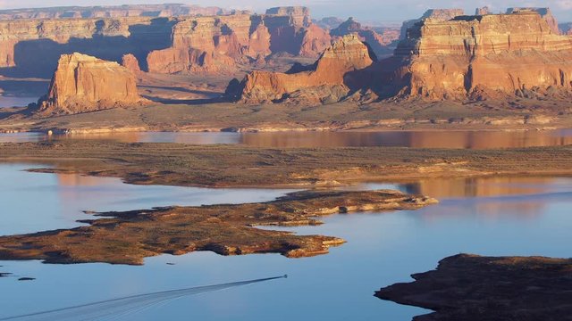 Boat moving across Lake Powell viewing a reflection of the landscape