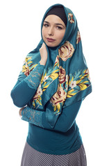 Fashion model wearing hijab for conservative modern clothing on a white background.  The style is...