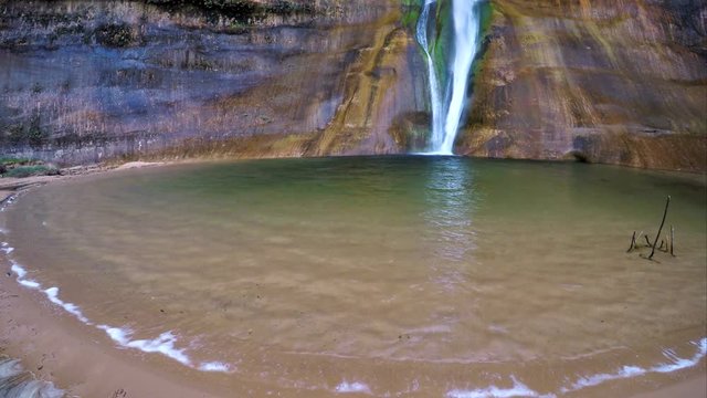 Wide view of waterfall and current against the sand