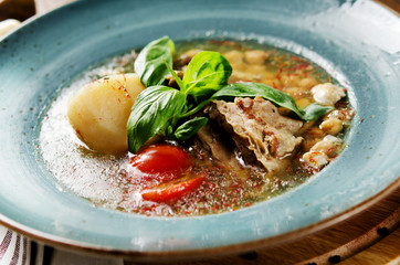 Soup with mutton broth with mutton meat, rice, chickpeas, potatoes, carrots, bell peppers, tomatoes, greens and oriental spices