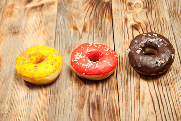 Colorful donuts on wooden background