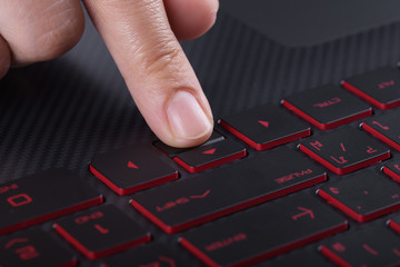 finger pushing arrow button on laptop keyboard