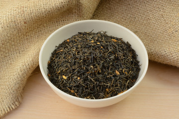 Loose jasmine dried tea leaves and flowers in white bowl