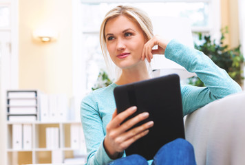 Happy young woman using her tablet