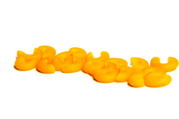 A lot of pasta. Dry pasta. Scattered pasta. Pasta background. Pasta in form of shells. Macaroni products. Macaroni background. Food background.