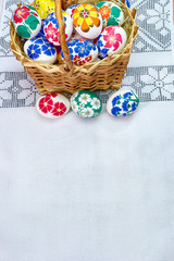 Fototapeta na wymiar Braided Easter basket with hand-painted eggs on a beautiful tablecloth