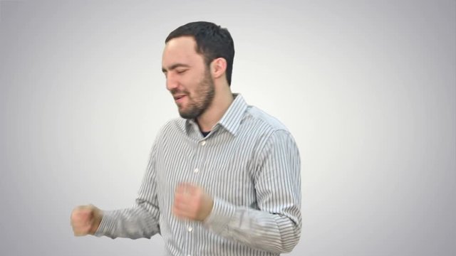Bearded young man happily dancing and singing on white background.