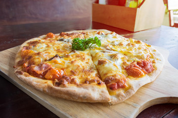 Delicious fresh pizza served on wooden plate.