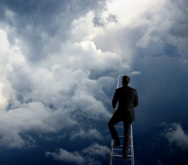 Businessman standing on ladder high in sky. Business concept.
