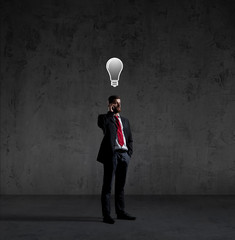 Obraz premium Businessman with smartphone has an idea. Dark and dramatic background. Business, solution, concept.