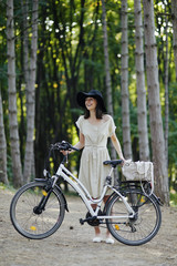 Fototapeta premium Young woman against nature background with bike