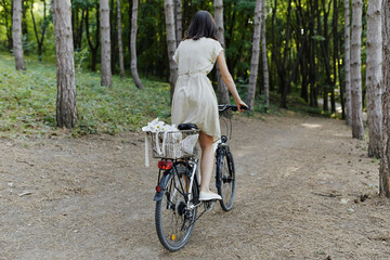 Fototapeta premium Young woman against nature background with bike