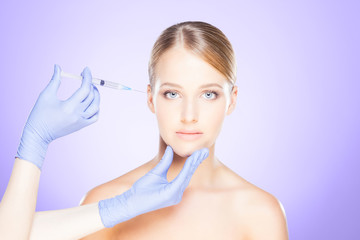 Doctor injecting in a beautiful face of a young woman. Plastic surgery concept.