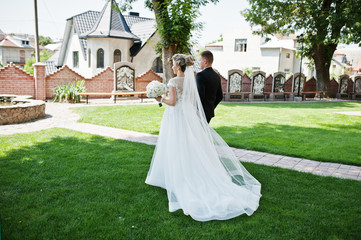 Stylish wedding couple walking in love on green lawn.