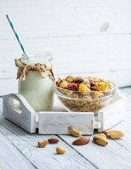 healthy Breakfast with milk in the jar and muesli with nuts