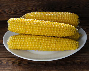Fresh corn on cobs on rustic wooden table, closeup. Selective focus
