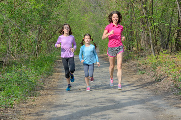 Obraz premium Family fitness and sport, happy active mother and kids jogging outdoors, running in forest 