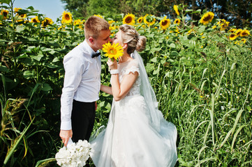 Wedding couple at sunflowers field in love.