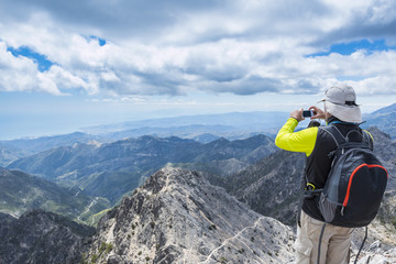 Hiker man taking pictures of mountains