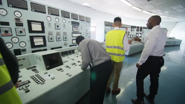  Mixed ethnicity team of engineers working in power station control room