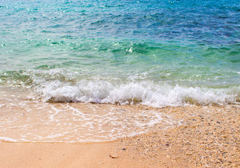 Turquoise sea water over white sand beach. Clean and relaxing sea wave splashes over seashore.