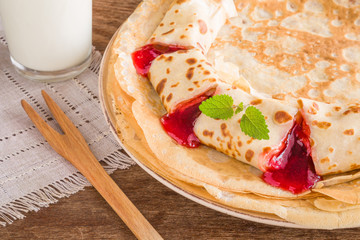 Tasty, sweet pancakes with strawberry jam. Homemade pastries. Russian Shrovetide traditional meal. 