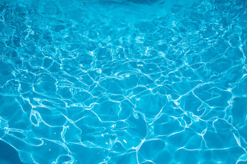 Blue and bright ripple water and surface in swimming pool , Beautiful motion gentle wave in pool